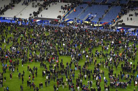 Football fans gather in the field as they wait for security clearance to leave the Stade de France in Saint-Denis, north of Paris, after the friendly football match France vs Germany on November 13, 2015 following shootings and explosions near the stadium and in the French capital.  A number of people were killed and others injured in a series of gun attacks across Paris, as well as explosions outside the national stadium where France was hosting Germany.   AFP PHOTO / FRANCK FIFE        (Photo credit should read FRANCK FIFE/AFP/Getty Images)